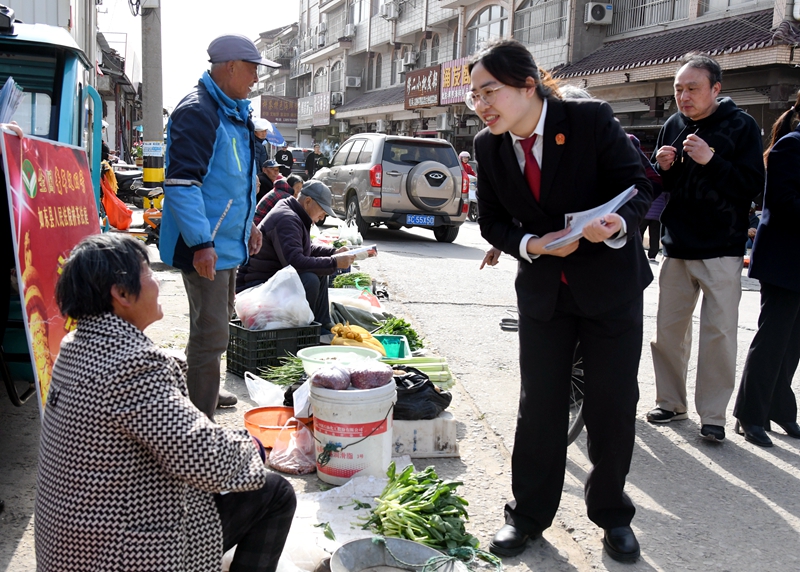 ①干警在“法律早市”向菜农发放普法宣传折页.jpg