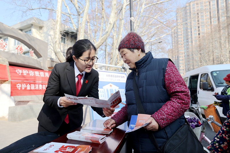 161773627732772254.jpg 新沂法院开展“依法维权 共促消费公平”主题宣传活动——该图为干警为市民讲解法律知识——王雨璠摄.JPG